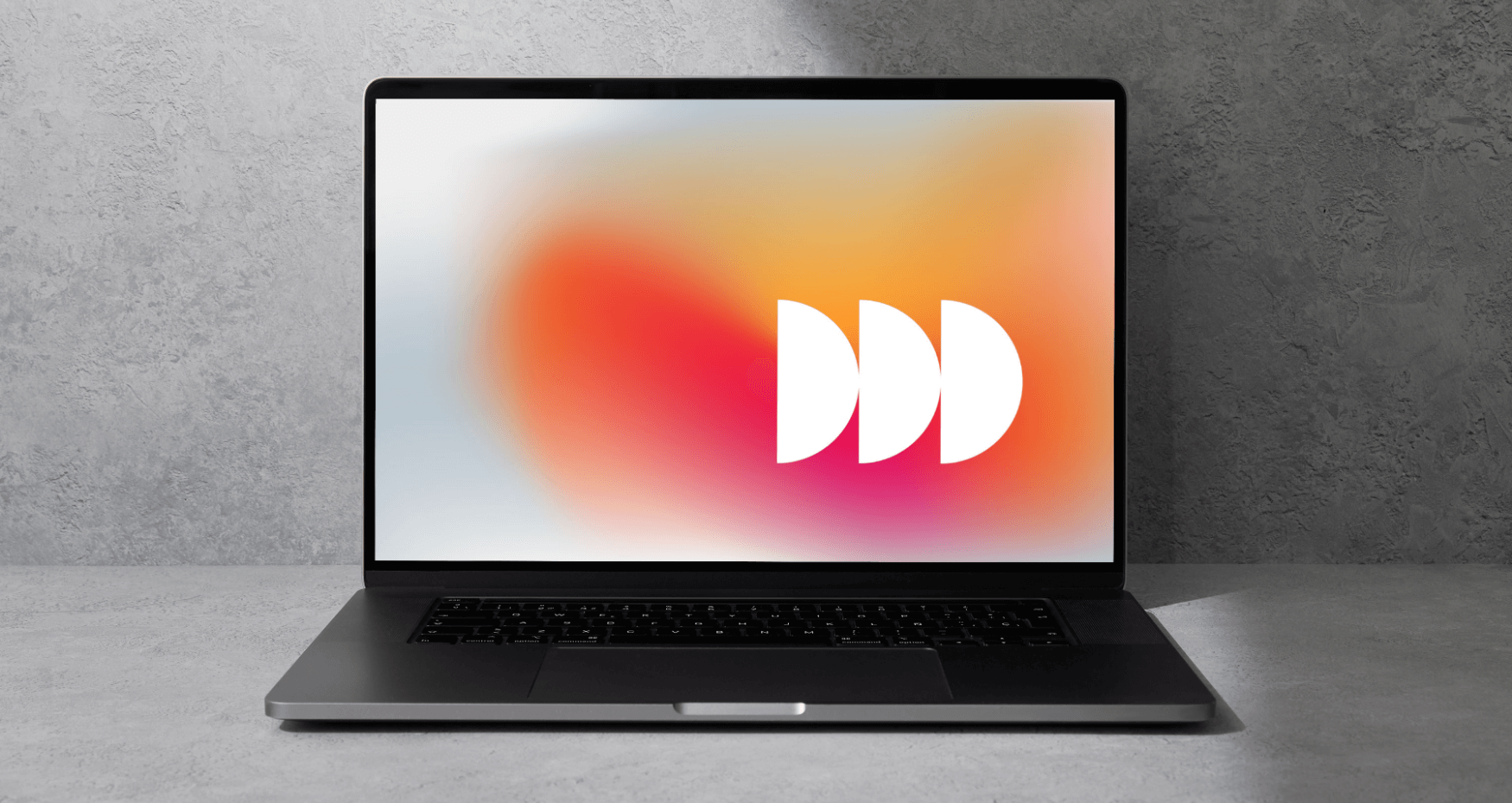 Ein Laptop auf einer grauen Fläche zeigt einen abstrakten, farbigen Verlaufshintergrund mit drei sich überlappenden weißen Halbkreisen - ideal für eine digitalagentur münchen, die sich auf KI und Automatisierung spezialisiert hat. - NINE brackets Digitalagentur München