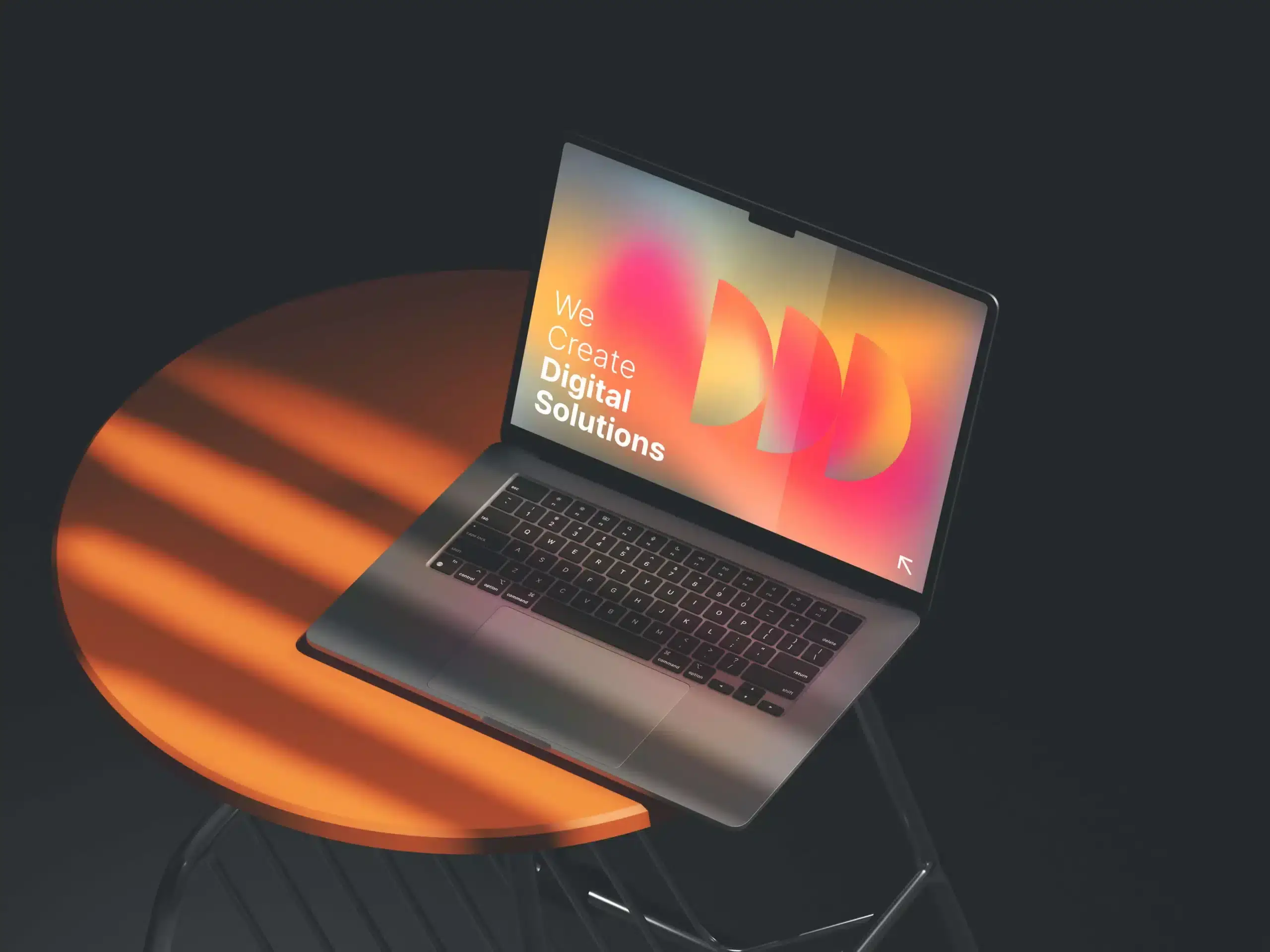 Ein Laptop steht auf einem orangefarbenen runden Tisch, auf dem ein bunter Bildschirm mit der Aufschrift 