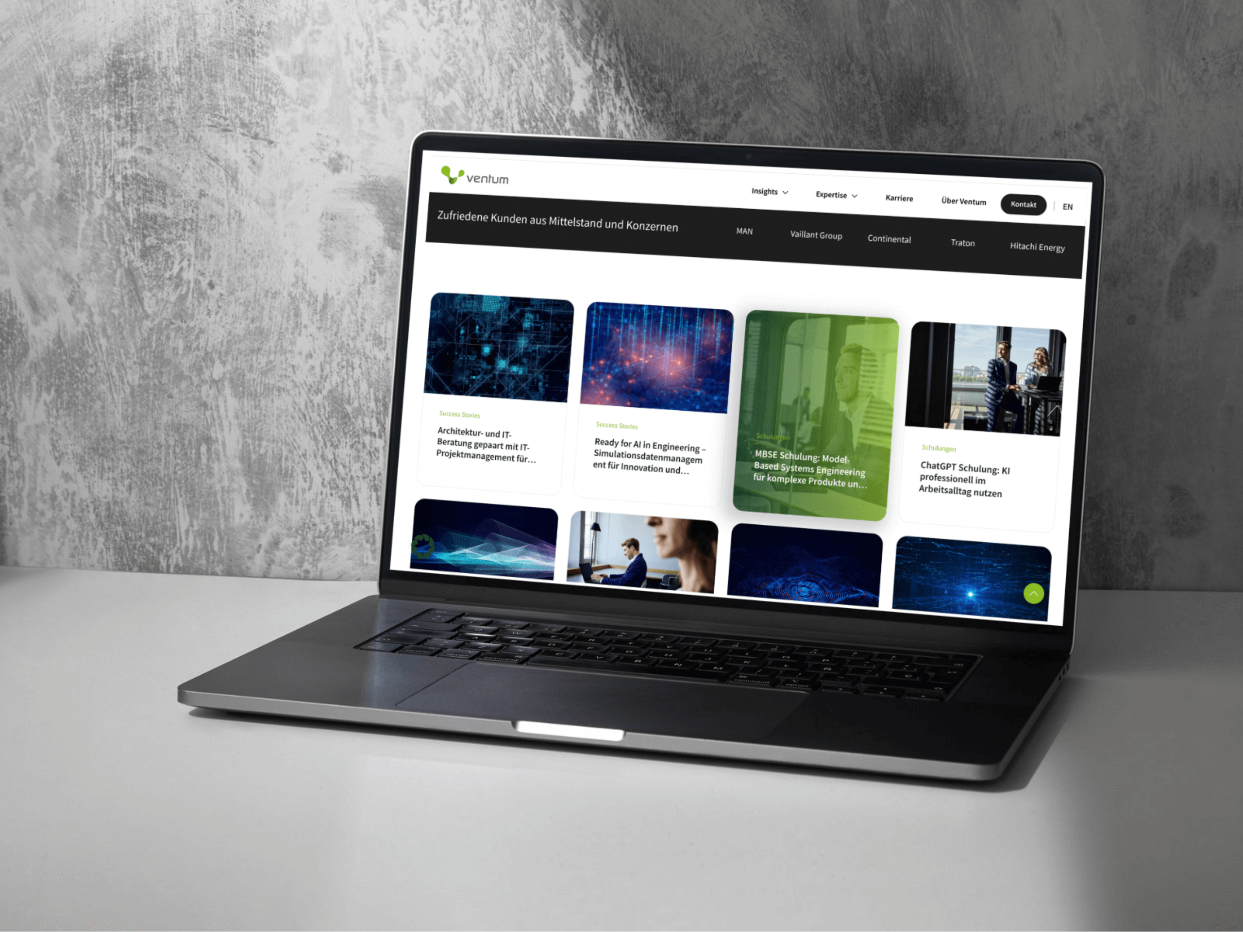 Ein Laptop auf einer grauen Oberfläche zeigt eine Unternehmenswebsite mit einem Raster-Layout, das Artikel, Bilder und Textblöcke enthält. Der Header zeigt das Ventum-Logo mit deutschsprachigen Navigationsmenüs, die die Kompetenz einer führenden B2B-Agentur in der Digitalberatung widerspiegeln. - NINE brackets Digitalagentur München
