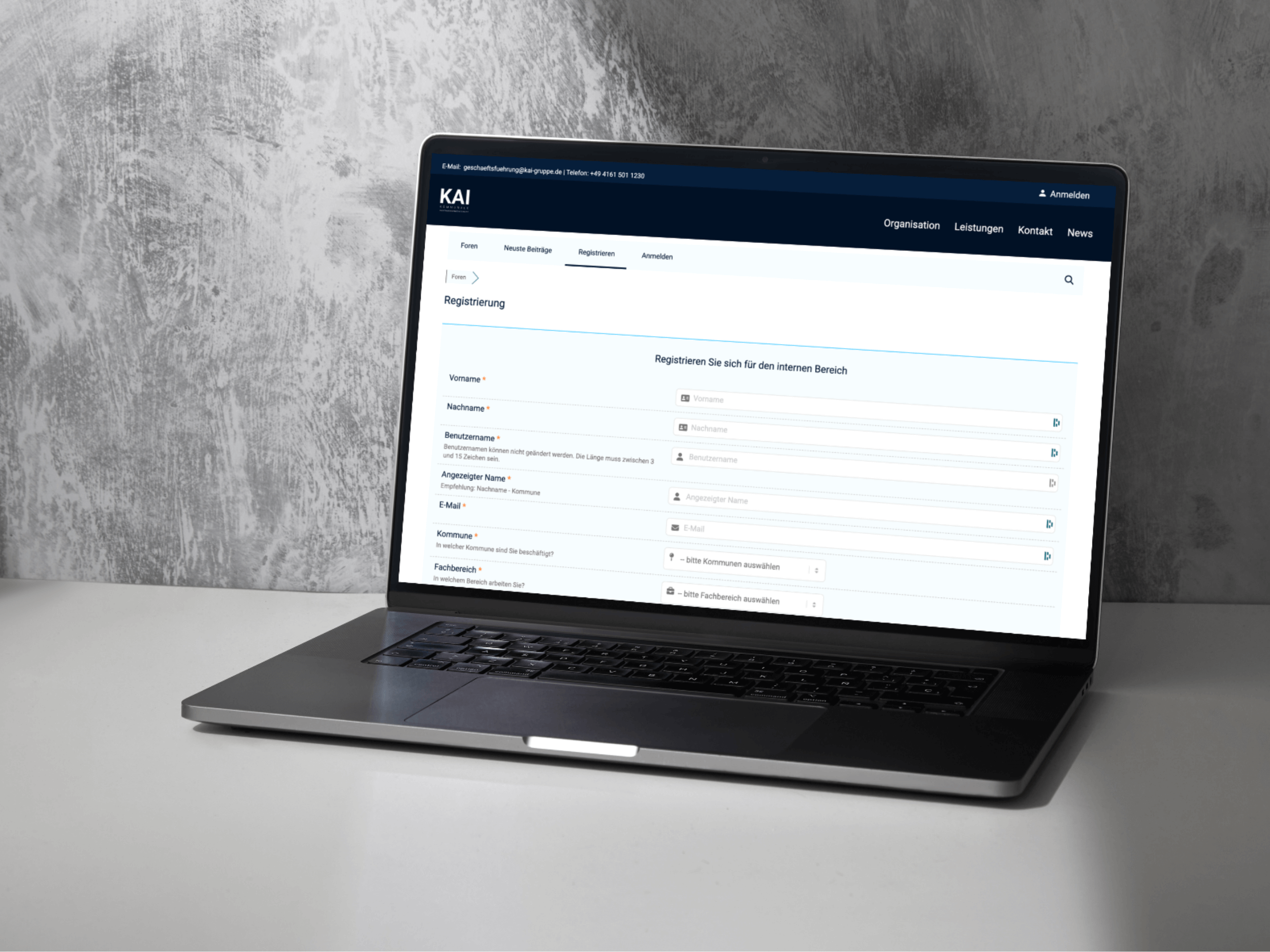Ein Laptop auf einer grauen Fläche zeigt ein Anmeldeformular auf der KAI-Unternehmenswebsite mit Feldern für Benutzerinformationen wie Name, E-Mail, Rolle und Kontaktdaten - und verweist auf die digitale Beratung und moderne ki und automatisierungs-Lösungen. - NINE brackets Digitalagentur München